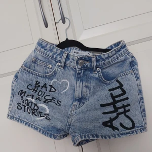 Blå jeansshorts med tryck från FB Sister - ⚠️ Skriv till mig innan köp!⚠️Snygga blå jeansshorts från FB Sister med coolt svart tryck: 'BAD CHOICES MAKE GOOD STORIES' och 'CHILL' samt vita hjärtan. Klassisk femficksmodell i tvättad denim, perfekt för en avslappnad och trendig look.