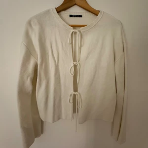 Vit kofta med knyt från Gina Tricot - Superfin vit kofta från Gina Tricot i mjukt material. Den har tre knyt framtill och rund halsringning. Perfekt att slänga över en topp eller klänning för en chill look. Långärmad och enkel att styla till olika outfits.