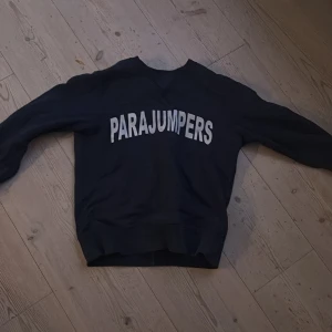 Mörk blå sweatshirt från Parajumpers - Mörk blå sweatshirt från Parajumpers med stor vit logga över bröstet. Klassisk rund halsringning och långa ärmar. Mjuk och skön bomullskänsla, perfekt för en avslappnad stil. Jag säljer för att den är för liten.  Storleken är xxs och passar dig som är runt 160cm
