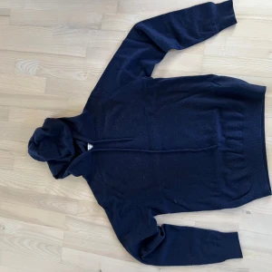 Merinulls hoddie - Mörkblå merinoulls hoddie från Tiger of Sweden. Tecken på användning men har fortfarande mycket kvar att ge. Nypris 1 999 kr. Priset kan diskuteras vid snabb och smidig affär. Vid frågor och funderingar så är det bara att göra av er!!
