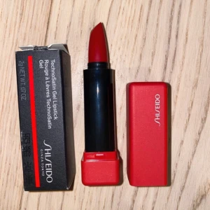 Shiseido rött läppstift TechnoSatin - Jag säljer ett helt nytt och oanvänt läppstift från Shiseido i den perfekta röda färgen 416. Det är en fantastisk produkt som ger intensiv färg och glans. Köpt för 460 kr.  Vänligen läs min bio innan du gör ett köp; där hittar du bland annat information om leveransprocessen med mera 😊  #Shiseido #Läppstift #TillSaluh #Skönhet #Makeup #RödFärg .