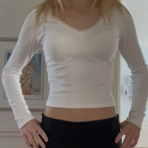 Vit långärmad topp med spetskant! - Vit långärmad vårtopp från Gina tricot, köptes för något år sedan men har aldrig använt den! Den har en fin v-ringning med spets och en slim passform, perfekt till fina vårdagar. 