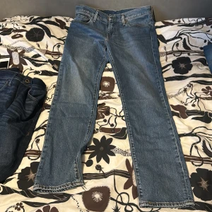 Levi's 511 blå jeans W32 L32 - Säljer ett par klassiska Levi's 511 jeans i blå denim. Modellen har en slim passform med raka ben och normal midja. Jeansen har fem fickor, gylf med dragkedja och tydliga kontrastsömmar. Perfekta för dig som gillar en tidlös och stilren look. Inga defekter och använda 1 gång! 