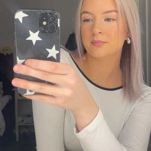 Vit långärmad topp med svart kant och öppen rygg - Säljer en stilren vit långärmad topp med svart kant runt halsringningen och även bak på ryggen då det är öppen rygg, super fin men kommer ej till användning längre 🤍