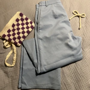 Ljusblå kostymbyxor från Boohoo - Snygga ljusblå kostymbyxor från Boohoo med raka ben och klassisk passform. Byxorna har hällor för bälte, diskreta fickor och stängs med hake och dragkedja. Perfekta för en clean och stilren look.