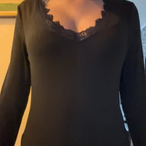 Svart tröja med taggar  - En svart liknade intimissi tröja i svart, lång och varm, har använt en gång, har fått små fläckar som går att tvätta bort enkelt.