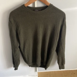 Olivgrön ulltröja från Oscar Jacobson - Säljer en olivgrön, klassisk rundhalsad tröja från Oscar Jacobson. Tröjan är i mjuk ull och har ribbade muddar vid ärmslut och nederkant. Perfekt för lager-på-lager och enkel att matcha med jeans eller chinos. Inga defekter, pris kan diskuteras.