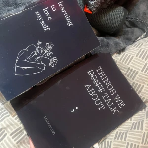 Things We Don't Talk About - En bok med stilren svart omslag och titeln 'Things We Don't Talk About'. Perfekt för dig som gillar djupa och känslosamma texter. Omslaget har en minimalistisk design med ett semikolon, vilket ger en modern och personlig känsla.