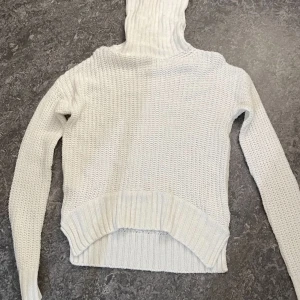 Vit stickad polotröja från 157 - Säljer en vit stickad polotröja från 157 i storlek XS. Tröjan har en hög, ribbad polokrage och är långärmad med grovstickad struktur. Perfekt för lager-på-lager och chill höst- och vinterstil.
