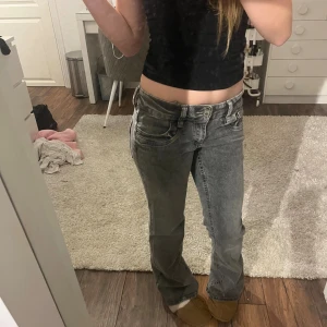 Gråa lågmidjade bootcut jeans - Säljer ett par gråa jeans med låg midja och bootcut-ben. Storlek 164, säljer för att jag inte använder. Använd kanske tre gånger så nästan som nya!