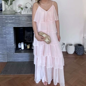 Rosa volang långklänning - Verkligen så fin volanglångklänning från Vila i ljusrosa. Klänningen är använd en gång och i storleken L för att nå ner till fötterna på mig som är 170. 
