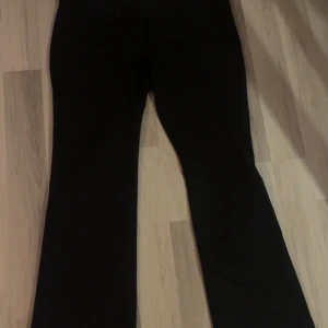 Svarta lågmidjade bootcut kostymbyxor i storlek L - Svarta kostymbyxor från Lager 157 i storlek L. Lågmidjad, använda en gång. Säljes pga för stora för mig. 