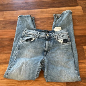 Blå jeans från Replay, modell Thad - Säljer ett par klassiska blå jeans från Replay, modell Thad. Jeansen har fem fickor, normal passform och snyggt tvättad denim med ljusa partier. Perfekta för dig som gillar en tidlös och avslappnad stil. Materialet är slitstarkt jeans i bomull.