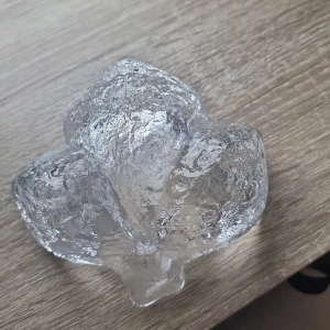 Dekoration  - Denna produkt är en dekorativ glasskål med organisk form och texturerad yta. Skålen är tillverkad i klart glas och har inga synliga defekter eller skador. Passar utmärkt som prydnad eller för servering av småsaker. Skicket är mycket gott.