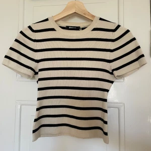 Randig topp Gina Tricot - Fin ribbad beige/svart randig topp från Gina Tricot i strl s. Cropped och stretchig