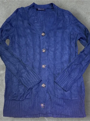 Blå kabelstickad kofta med knappar - Säljer vi en riktigt fet cardigan som passar perfekt nu till vinter och om du vill utveckla din stil!  Färg: 🟦  Den är i storlek L men passar även M 🙏  Skick: 8/10 ⭐️  Hör av er vid minsta lilla fundering! 🤩