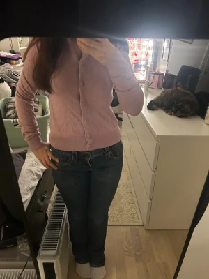 Ljuslila kofta från H&M, storlek S - Supersöt ljuslila kofta från H&M i storlek S. Koftan har rund halsringning, knappar framtill och är långärmad. Tillverkad i mjukt material med 70% viskos och 30% polyamid, vilket gör den riktigt skön och lätt att bära. Perfekt att slänga över en topp eller klänning.