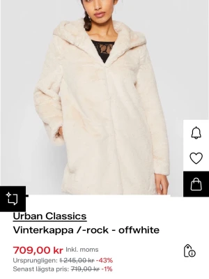 Urban Classics offwhite pälsjacka med huva - Säljer en fluffig och mjuk offwhite pälsjacka från Urban Classics. Jackan har stor huva, långärmad design och är i syntetmaterial som ger en lyxig vibe. Perfekt för dig som vill ha en cozy och trendig look under vintern. Jackan är rak i modellen och har en clean finish utan synliga knappar.