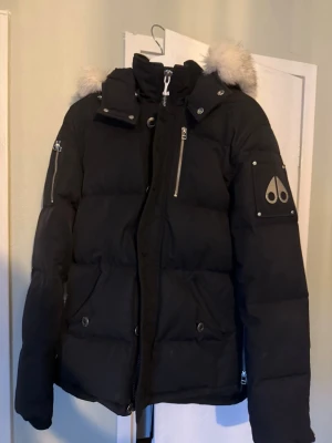 Svart pufferjacka från Moose Knuckles - Svart vinter jacka  från Moose Knuckles, säljer nu denna fina jacka  jag har haft den i ett år nu. Jackan köptes på NK i Göteborg så tags och kvitto finns, storlek S men passar nog M med. den är inprincip nyskick om det inte var allt så finns jag att kontaktas i dm!
