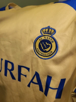 Al-Nassr FC hemmatröja för säsongen 2023-2024. storlek M - En gul och blå Al Nassr FC fotbollströja i storlek M, tillverkad i Turkiet med Aeroready-material. Christiano Ronaldo  7