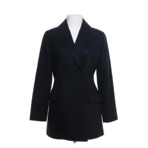 Mörkblå ullkappa - Säljer denna jättefina kappan i 80% ull från ett franskt märke som heter Cyrillus! 🤍 Nypris 2500 kr. Knappt använd och som ny 🤍 har fin passform, lite figurnära. Passar mig som är XS-S