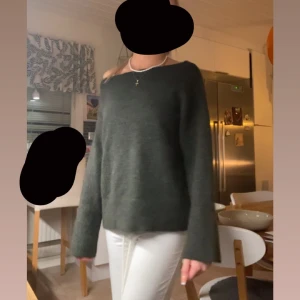 Mörkgrön stickad tröja med vid hals - Mysig mörkgrön stickad tröja med vid halsringning och långa ärmar. Tröjan har en loose passform och är perfekt för höstvädret. Enkel och stilren design som funkar till allt. Aldrig använd bara provat på.