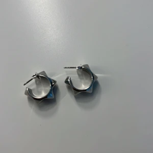 Silvriga chunky örhängen med kantig design - Säljer ett par chunky silvriga örhängen med cool, kantig och geometrisk form. De är runda hoops men med en edgy twist tack vare de vassa kanterna. Perfekta för dig som vill sticka ut med dina accessoarer.