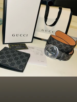 Svart Gucci bälte med plånbok - Säljer ett helt nytt Gucci-bälte och en matchande Gucci-plånbok i GG Supreme canvas. Båda är helt oanvända och endast uppackade för bilder. Allt kommer komplett med originalbox, påse, kontrollkort och kvitto från butik (nypris 4980 HKD för bältet). Jag är aktiv här på Plick och svarar snabbt, samt fraktar direkt samma dag som köp. Perfekt set som present eller för dig som vill höja din stil. Skriv vid intresse!