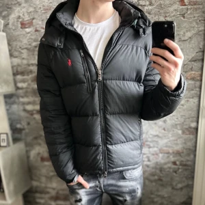 Ralph Lauren Gorham Jacka - Ok skick, sliten text vid nacken och sliten där man drar åt jackan, sista bilden. Storlek M passar dig som är mellan 175-185cm ungefär. Nypris ca 4000kr. Modellen är 185 cm, 79 kg. Självklart äkta - Kolla bara recensionerna! Passar bra nu till vintern. Skriv för mer information!🤝