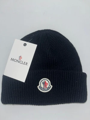 Moncler mössa - Säljer en helt ny och oanvänd Moncler mössa I storlek One Size