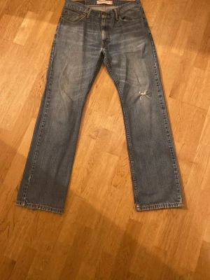 Levi's 505 straight fit jeans blå - Blå Levi's 505 jeans med straight fit. Jeansen har slitningar och en mindre reva på benet. Storleken är W32 och L32! Riktigt feta!!