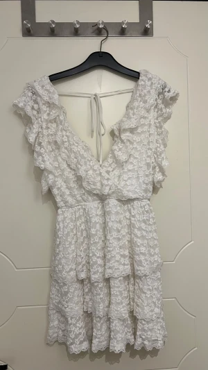 Vit studentklänning  - Super fin mönstrad studentklänning från Nelly, för referens är jag 163 cm lång och den var för kort för mig tyvärr, säljer därför vidare eftersom jag inte kommer kunna använda den! Skriv för bilder på!!