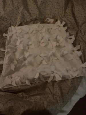 Perfekt jul/nyårskjol! - Jättefin kjol med 3d blommor som har strass i mitten, storlek XXS, nyskick men köpt på sellpy!