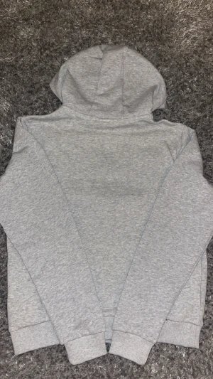 Grå hoodie med dragkedja från Lacoste - Snygg grå hoodie från Lacoste med hel dragkedja och klassisk krokodillogga på bröstet. Tröjan har huva, ribbade muddar och gröna detaljer vid halsen. Perfekt för chill dagar och streetwear-stil. Pris kan diskuteras 