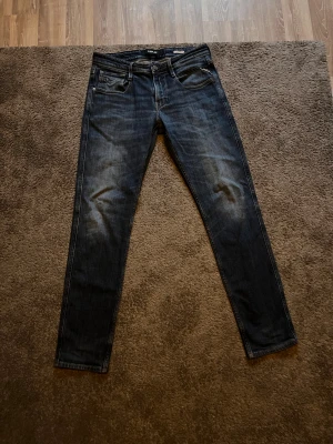 Replay Ambas mörkblå slim jeans - Säljer ett par mörkblå slim jeans från Replay med klassisk femficksdesign och snygga slitningar på framsidan. Jeansen har normal midja och detaljerade sömmar på bakfickorna. Perfekt passform.