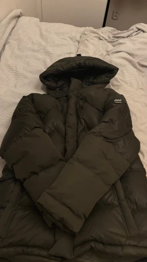 Mörkgrön/gråish pufferjacka Mountain Works S - Säljer en mörkgrön/gråish pufferjacka från Mountain Works i storlek S. Jackan har stor huva, dragsko i halsen och diskret logga på ärmen. Den är inte använd. Finns en likadan i storlek M på min sida om den ej är såld. Pris går att diskutera vid snabb affär💗