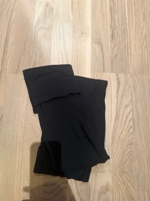Svarta bootcut leggings från Gina tricot  - Säljer ett par svarta leggings från gina tricot med bootcut-modell och hög midja. De är tillverkade i mjukt stretchigt material som sitter skönt och följer kroppen. Perfekta för dig som gillar en enkel men trendig look.