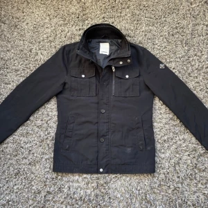 J Lindeberg field jacket  - Säljer denna riktigt feta j Lindeberg field jacketen!⭐️Skick : 8,5/10, stygnen har lossnat på undersida arm kan lätt lagas hemma och smått smutsig, knappen högst upp har också lossnat annars fint skick🙌Storlek S passar S!⭐️NYPRIS = 4000kr! Hör gärna av er om ni har funderingar!👍