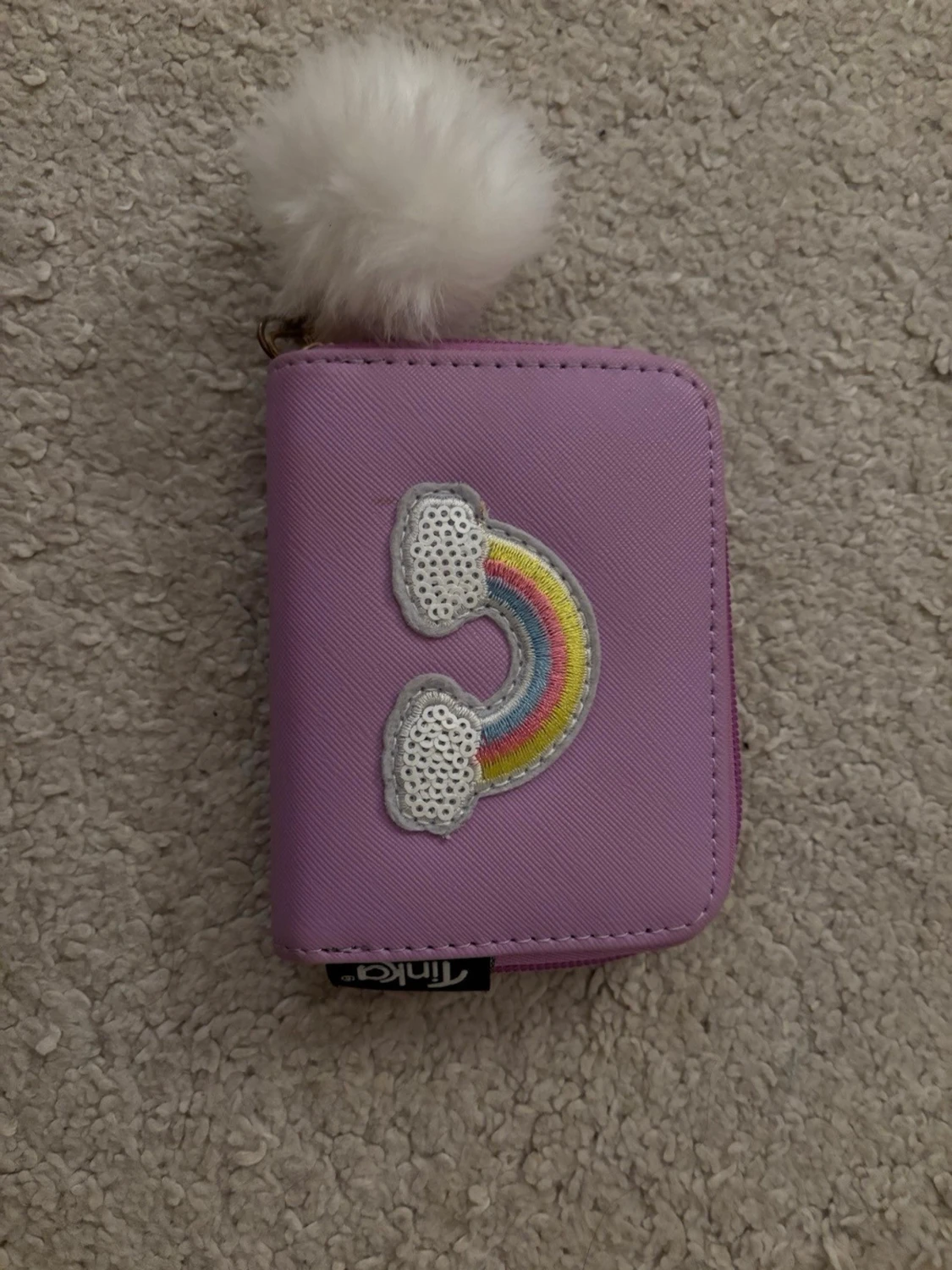 Lila plånbok med regnbågsdetalj