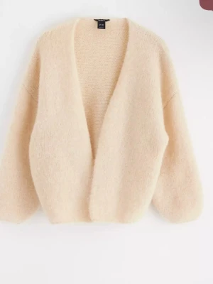 Lindex kofta  - Mysig beige kofta från Lindex i fluffigt stickat material. Koftan har en öppen front utan knappar, ballongärmar och en loose passform som ger en avslappnad vibe. Perfekt för lager på lager under höst och vinter.