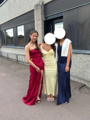 Röd balklänning  - Säljer en jättefin röd balklänning från Nelly. Den är endast använd en gång och är i mycket bra skick. Nypris var 800 kr. Klänningen är axelbandslös och har en slits (se bilder).