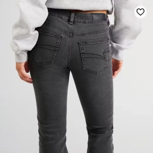 Bootcut svarta/gråa jeans från Junkyard  - Snygga svarta jeans från junkyard med bootcut passform och klassiska fickor. Jeansen har låg midja och är tillverkade i mjukt denim-material med stretch för extra komfort och i bra skick. Fler bilder finns! Obs: de har små hål på insidan av midjan då det suttit en resor där tidigare. Inget som syns eller känns utifrån 😄