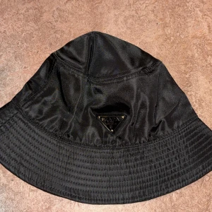 Svart bucket hat från Prada - Helt ny hat i toppskick säljes. Bästa replikan du kan hitta! Kan mötas upp eller skickas.