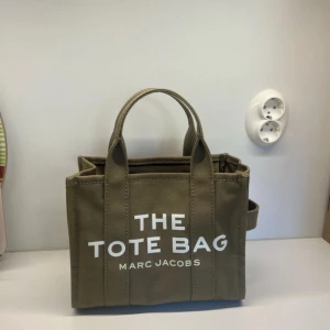Grön tote bag från Marc Jacobs - Säljer den här super fina tote bag från Marc jacobs, perfekt för skolan och andra saker, ganska liten men väldigt rymlig. Köpt i augusti förra året men på grund av att det blev vinter så fort och att jag har andra väskor som jag tycker om mer så har den endast använts max 5 gånger. Självklart äkta, jag tror att jag har kvitto i min låda hemma! Pris kan diskuteras!💕