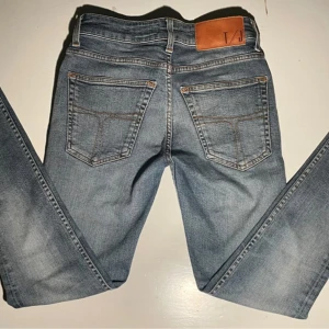 Ljusblå tiger of sweden jeans  - Snygga ljusblå jeans från T/J med klassisk femficksdesign och bruna kontrastsömmar. Jeansen har en rak passform och är tillverkade i mjukt denimtyg. Perfekta för en avslappnad och trendig look.