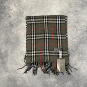 Burberry Halsduk - Skick: 7/10 (Vintage), begagnad, inga defekter. | Vad som ingår: Endast halsduken. | Ordinarie pris: +- 4000 SEK / 400 €. | ​​OBS: Halsdukarna finns i samma färgsättning men kan skilja sig något i modell eller detaljer, beroende på tillverkningsår eller kollektion