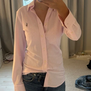 Rosa randig skjorta från Ralph Lauren - Säljer en jätte fin rosa randig skjorta från ralphlauren. Den är köpt i USA 🇺🇸!! Den är i strlk M men är lika liten som strlk S så skriver att den är i strlk S