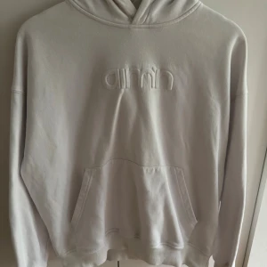 Vit hoodie från Aim'n med huva - Säljer en vit hoodie från Aim'n i storlek XS. Tröjan har broderad logga framtill. Säljer för den inte kommer till användning längre. 