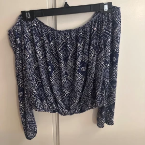 Blå offshoulder blus med mönster - Säljer en blå offshoulder blus med vitt mönster. Skönt material. 