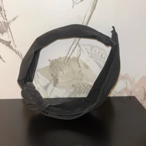 Svart knutet diadem - Snyggt svart diadem med knut framtill, tillverkad i lyxig sammet som ger en lyxig känsla. Diademet är brett och har en stilren, enkel design som passar perfekt för att lyfta din look. Perfekt accessoar för dig som gillar minimalistisk stil.